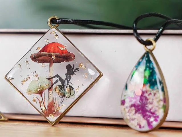 Clear resin pendants with pressed botanicals and gold flake cast in bezel settings