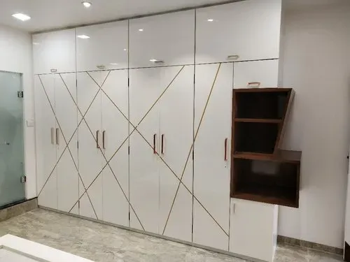Glossy laminate-faced wardrobe cabinet with decorative gold trim detailing